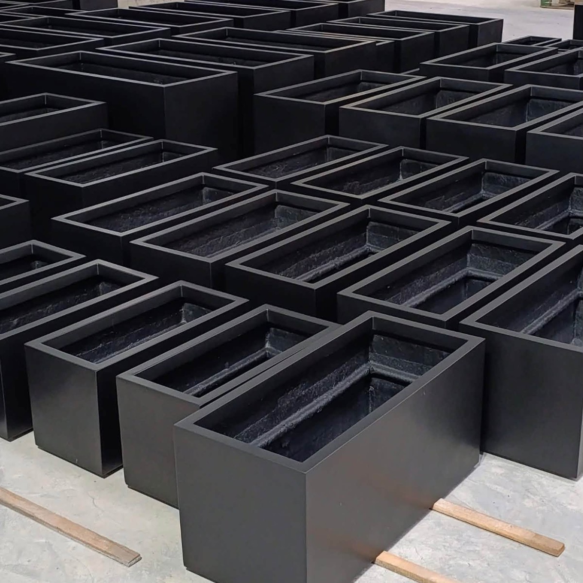 Black rectangular fiberstone trough planters in production at Furnio