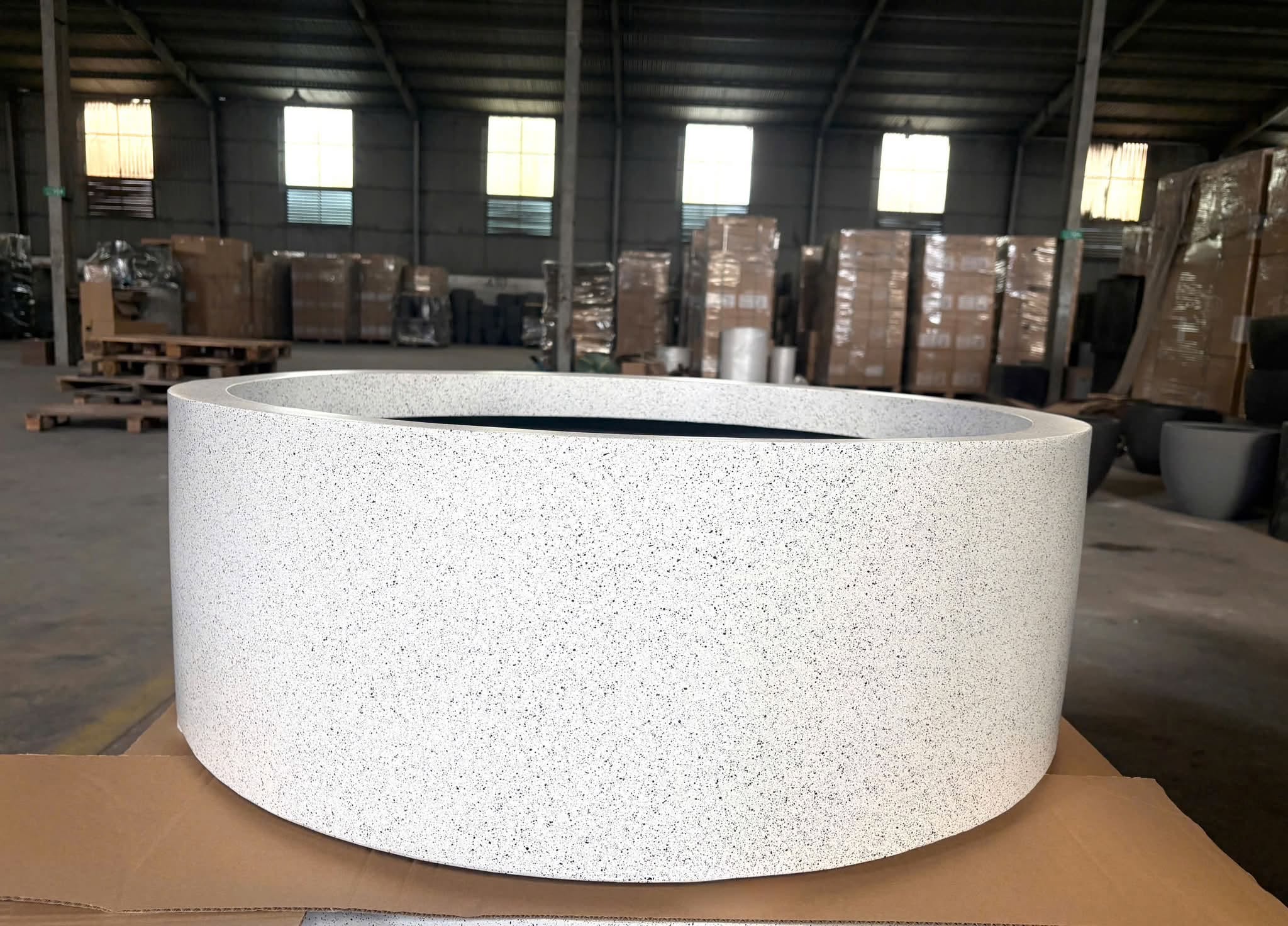 Round fiberstone planter with a terrazzo finish by Furnio